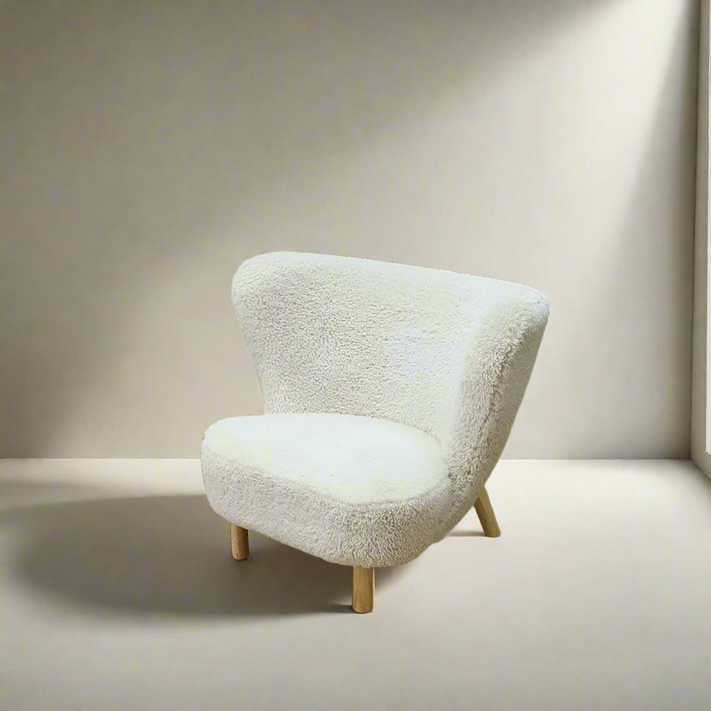 Fluffy beige armchair on a wooden floor with text indicating dimensions.